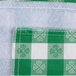 A white table cover with green and white checkered fabric and a white square.