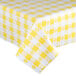 A yellow and white checkered vinyl table cover with white and yellow flowers.