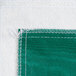 A green vinyl table cover with flannel back and white threads.