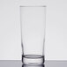 An Arcoroc customizable cooler glass with a round bottom on a white surface.
