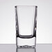An Arcoroc tall square shot glass with clear glass on a table.