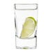 An Arcoroc tall square shot glass with a lime wedge in it.