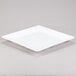 A Tablecraft white square melamine tray with a white rim.