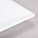 A Tablecraft white square melamine tray with a handle.