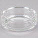 A clear glass Arcoroc ashtray with a small hole in the center.
