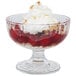 A glass bowl with a dessert and whipped cream.