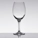 A close-up of a clear Stolzle Nadine Bordeaux wine glass on a reflective surface.