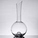 A clear glass decanter with a thin curved neck.