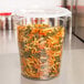 A translucent plastic Cambro food storage container filled with spiral pasta.