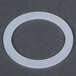 A white plastic gasket with a white circle.