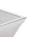 A close up of a square stainless steel bowl with a white interior.