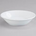 An Arcoroc white china bowl on a gray surface.
