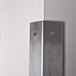 A stainless steel wall corner guard from Advance Tabco on a wall corner with screws.
