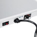 A close-up of a white Hatco Glo-Ray heated shelf warmer with a power cord attached.