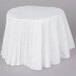 A white tablecloth on a table with pleated edges.