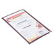 A burgundy Menu Solutions triple panel menu jacket on a table with a menu in it.