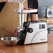 A person using a Galaxy electric meat grinder to grind meat on a counter.