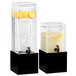 A couple of Cal-Mil black square bases for glass beverage dispensers filled with water, lemons, and ice.
