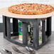 A pizza on a Tower of Pizza stand on a table.