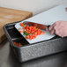 A person using a knife to cut tomatoes on a cutting board in a black HS Inc. Charcoal Prep n Serve Deep Tote.