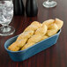 A blue HS Inc. breadstick basket on a table with bread in it.