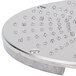 A Robot Coupe hard cheese grating disc, a circular metal object with small holes.