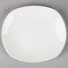 A Tuxton Napa AlumaTux Pearl White china plate on a gray surface.