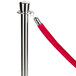 A silver metal pole with a red rope.