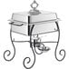A Choice half size chafer with a classic silver lid on a table with a black wrought iron stand.