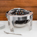 A Vollrath New York Retractable Round Chafer with mussels inside.