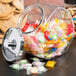 An Anchor Hocking glass jar filled with candy and cookies.