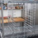 A Metro chrome tray slide attached to a metal rack in a kitchen.