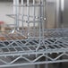 A Metro chrome tray slide attached to a metal rack.
