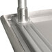 An Advance Tabco stainless steel open base work table with a metal pipe.