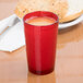 A close-up of a red Cambro plastic tumbler filled with a red drink.