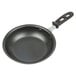 A Vollrath stainless steel frying pan with a black interior and black handle.