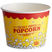 A yellow and red Carnival King popcorn bucket with white and red text filled with popcorn.