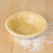 A pie crust in a D&W foil tart pan on a table.