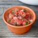 A GET pumpkin diamond melamine bowl filled with salsa on a wood table.