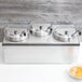 A Vollrath countertop food warmer with three stainless steel pots inside.