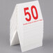 A stack of Cal-Mil double-sided table tents with red numbers on a table.