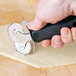 A hand using a Tablecraft stainless steel double pastry cutter to cut dough.