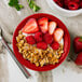 A Tuxton cayenne fruit dish filled with granola and strawberries.
