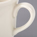 A close up of a Homer Laughlin ivory china mug with a handle.