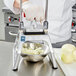 A person using a Vollrath Redco InstaCut 3.5 to dice onions.