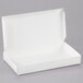 A close-up of a 7 1/2" x 4" x 1" white candy box with an open lid.