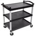 A black Cambro three shelf utility cart on a table.