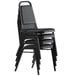 A stack of Lancaster Table & Seating black stackable banquet chairs with padded seats.