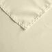 A close up of an ivory square table cover with a corner hem.