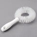 A white circular brush with a handle.
